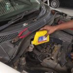 Mechanic checking engine oil levels during Mars Auto Care car service