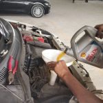 Mechanic checking engine oil levels during Mars Auto Care car service