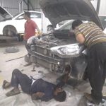 Mechanic checking engine oil levels during Mars Auto Care car service