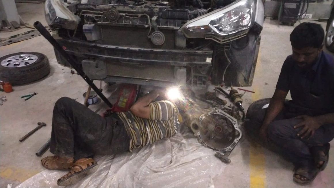 Mechanic checking engine oil levels during Mars Auto Care car service