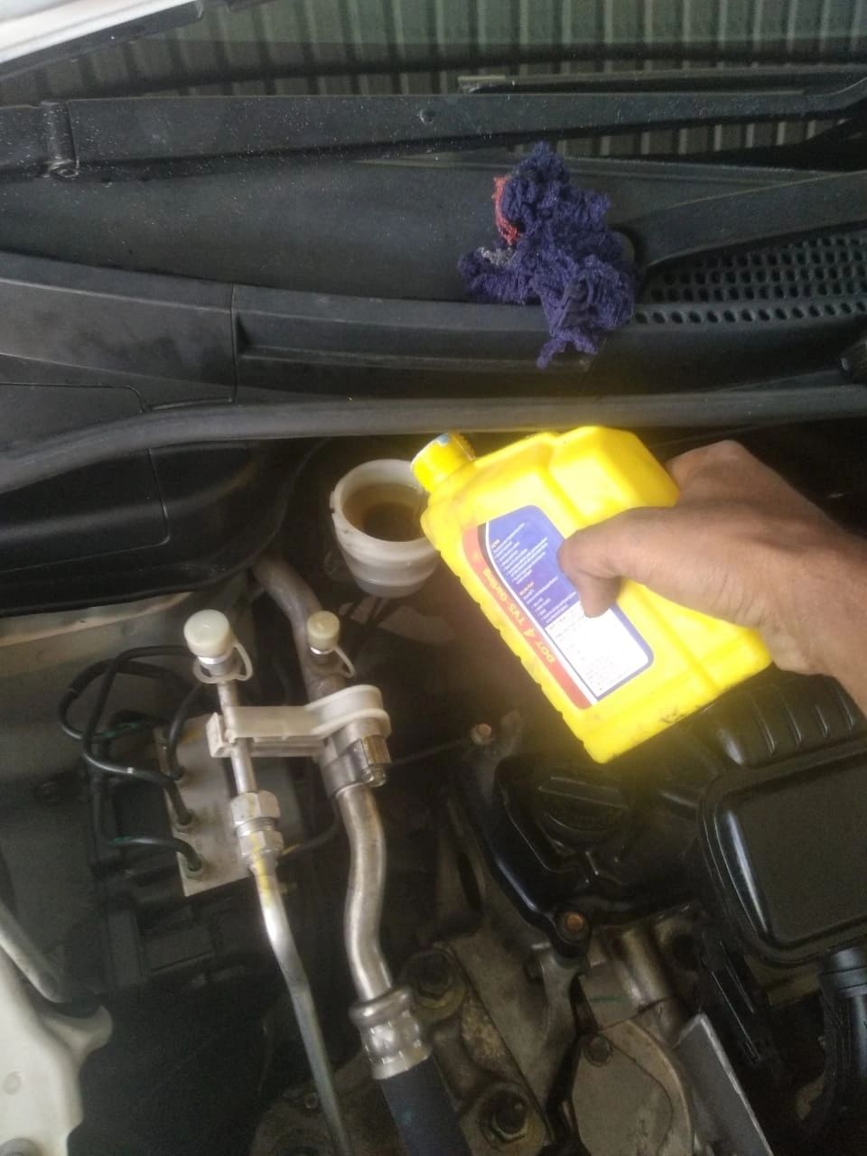 Mechanic checking engine oil levels during Mars Auto Care car service