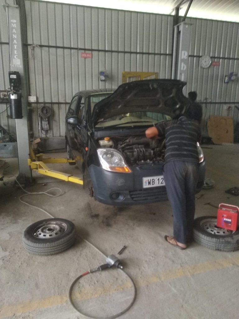Mechanic checking engine oil levels during Mars Auto Care car service