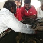 Mechanic checking engine oil levels during Mars Auto Care car service