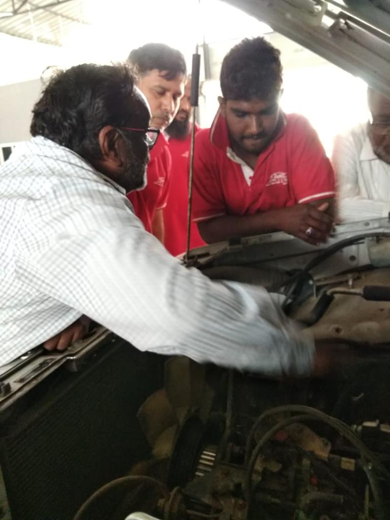 Mechanic checking engine oil levels during Mars Auto Care car service