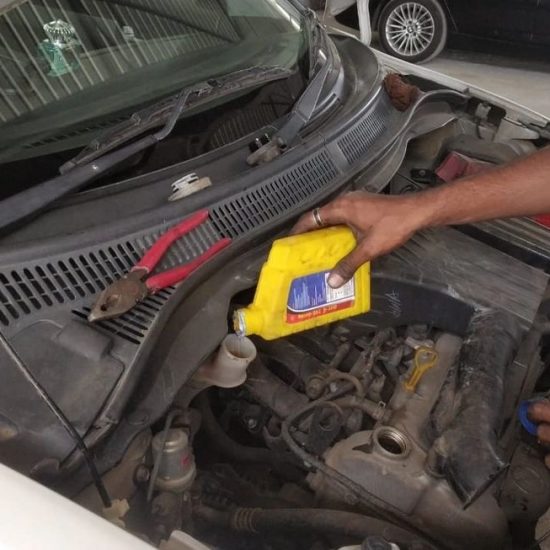 Mechanic checking engine oil levels during Mars Auto Care car service