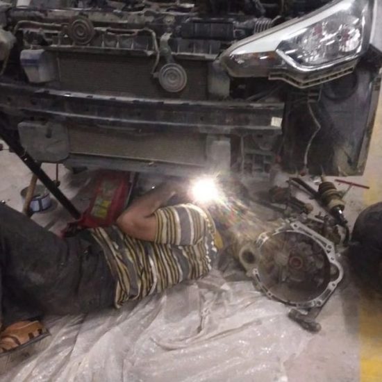 Mechanic checking engine oil levels during Mars Auto Care car service